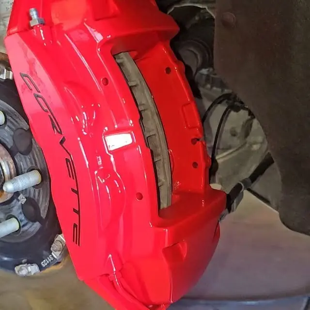 Corvette brake caliper painted bright red with the Corvette script in black