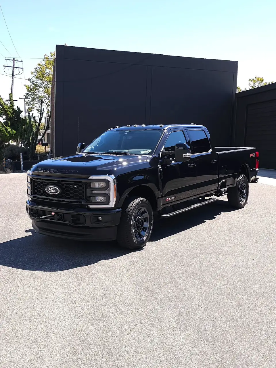 Black Ford F-250 Super Duty FX4 with clean gloss paint parked in front of a black wall